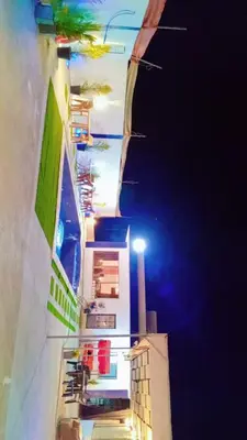 a building with lights on the side of it at night at Sky Blue Farm in Umm Jawzah