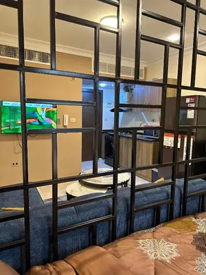 a room with a wall of windows and a tv at gardens studio استوديو الجاردنز 401 in Amman