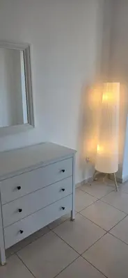 a dresser with a mirror and a lamp in a room at One Bedroom Damac Tower 8th Floor Boulevard Abdali غرفة وصالة فاخرة - برج داماك العبدلي البوليفارد الطابق الثامن in Amman