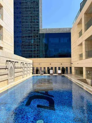 a large swimming pool in front of a building at One Bedroom Damac Tower 8th Floor Boulevard Abdali غرفة وصالة فاخرة - برج داماك العبدلي البوليفارد الطابق الثامن in Amman