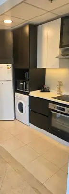 a kitchen with a dishwasher and a washer and dryer at One Bedroom Damac Tower 8th Floor Boulevard Abdali غرفة وصالة فاخرة - برج داماك العبدلي البوليفارد الطابق الثامن in Amman