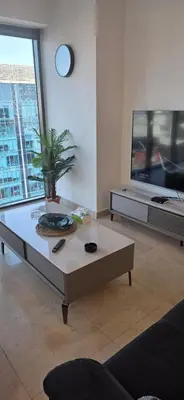 a living room with a coffee table and a tv at One Bedroom Damac Tower 8th Floor Boulevard Abdali غرفة وصالة فاخرة - برج داماك العبدلي البوليفارد الطابق الثامن in Amman