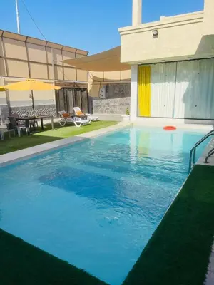 a large blue swimming pool with a frisbee in it at Firuza Farm Villa Vip in Al Rama