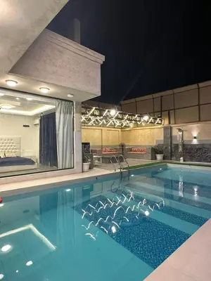 a large swimming pool at night with a large mirror at Firuza Farm Villa Vip in Al Rama