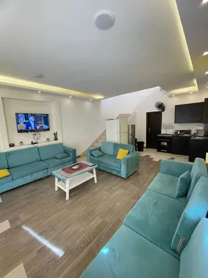 a living room with two blue couches and a table at Firuza Farm Villa Vip in Al Rama
