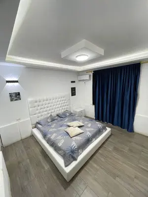 a bedroom with a large bed with a blue comforter at Firuza Farm Villa Vip in Al Rama