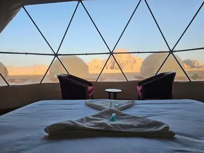 a robe on a bed in a room with windows at جمال رم in Aqaba