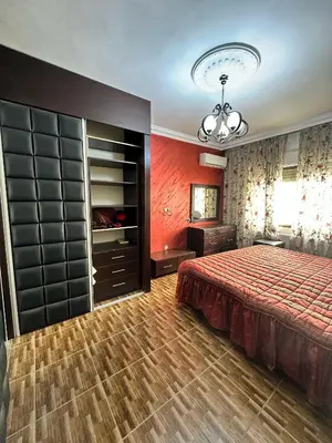 a bedroom with a bed and a chandelier at shafa badran شفا بدران ام الحجير in Amman