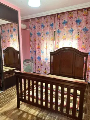 a crib in a room with a floral curtain at shafa badran شفا بدران ام الحجير in Amman