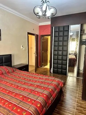 a bedroom with a large bed with a red blanket at shafa badran شفا بدران ام الحجير in Amman