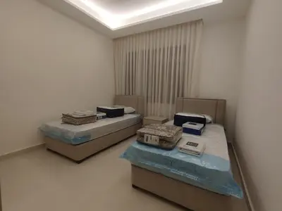 two beds in a room with boxes on them at Newly Built apartment Deir Ghbar in Amman