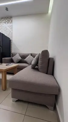a couch sitting in a living room with a table at يزن للاجنحة الفندقية in Aqaba