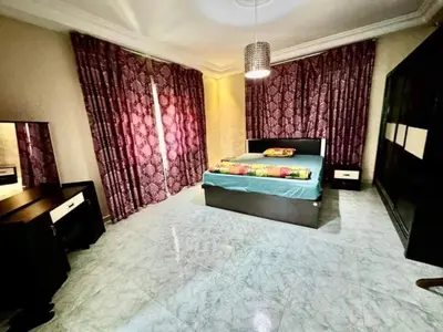 a bedroom with a bed and curtains and a television at VOV House in At-Tafilah
