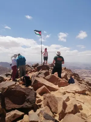 a group of people standing on top of a mountain at Wadi Rum safari camp in Wadi Rum