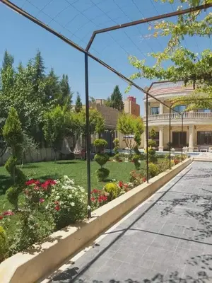a garden with flowers and a building in the background at الزئبق فارم in Maḩaţţat al Ḩafīf