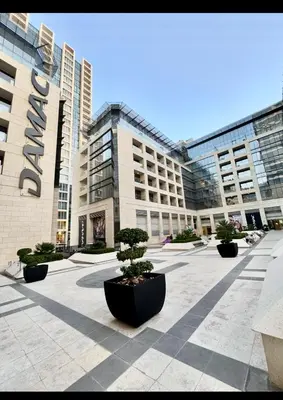 a large building with trees in front of it at Amman damac tower عبدلي عمان دماك Abdali Boulevard in Amman