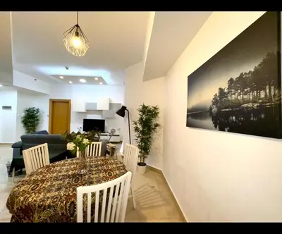 a dining room table with chairs and a painting on the wall at Amman damac tower عبدلي عمان دماك Abdali Boulevard in Amman