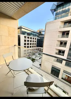 a balcony with a table and chairs on a building at Amman damac tower عبدلي عمان دماك Abdali Boulevard in Amman