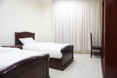 a hotel room with two beds and a chair at النخيل للشقق الفندقية ALnakheel hotel apartment in Aqaba