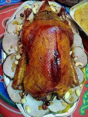 a cooked turkey on a plate with nuts on it at Bonuk House in Kufayrāt Abū Khīnan