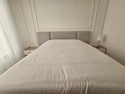 a white bed in a bedroom with a white bedspread at Shamsi Apartments 008 in Amman