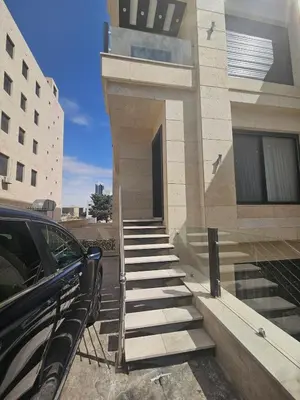 a car parked next to a building with stairs at Shamsi Apartments 008 in Amman