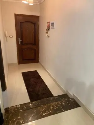 a hallway with a door and a rug in front of it at نسيم الرمثاء in Ar Ramthā