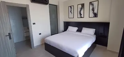 a bedroom with a large bed with white sheets at LV Spring Water Resort in Mukāwir