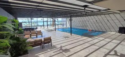 a swimming pool in a building with two benches at LV Spring Water Resort in Mukāwir
