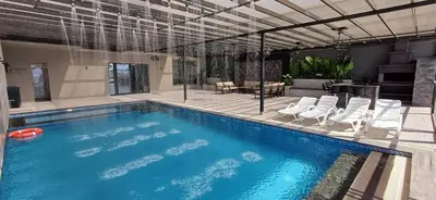 a swimming pool with chairs and a table at LV Spring Water Resort in Mukāwir
