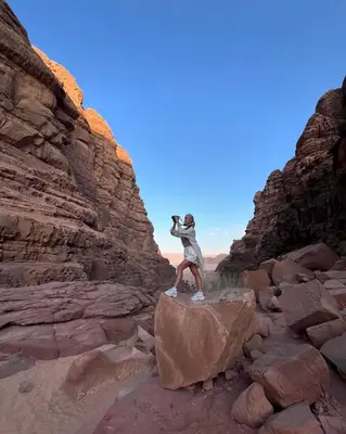 a man standing on a rock in a canyon at Wadi rum Mahmoud tours in Wadi Rum