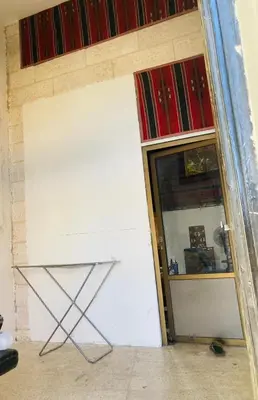 a mirror next to a room with a white wall at Bedouin House in Jurf ad Darāwīsh