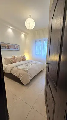 a bedroom with a bed and a large window at Modern One Bedroom with Steps from the Best Shops in Amman