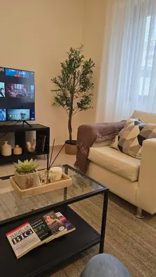 a living room with a couch and a table at Modern One Bedroom with Steps from the Best Shops in Amman