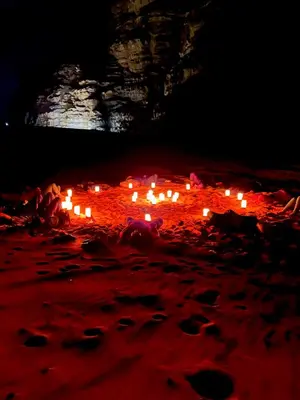a group of candles sitting on the beach at night at Faraj wadi rum in Disah