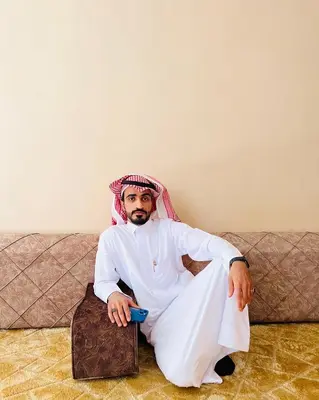 a man sitting on a couch holding a cup at Faraj wadi rum in Disah