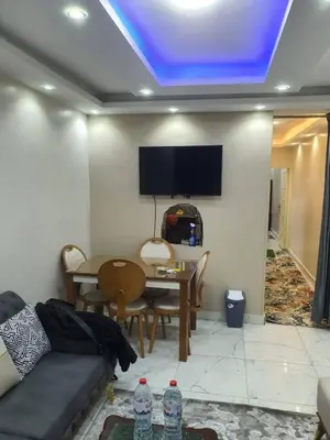 a living room with a couch and a tv on the ceiling at عبق التاريخ هاوس in Rujm al Ḩāwī