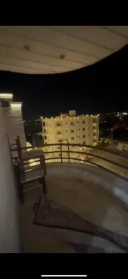 a view of a building at night with two benches at Beautiful Apartment in irbid in Aydūn