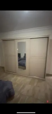 a room with a white wall and a bedroom at Beautiful Apartment in irbid in Aydūn