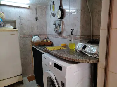 a kitchen with a washing machine under a counter at بيت الحجر in Amman