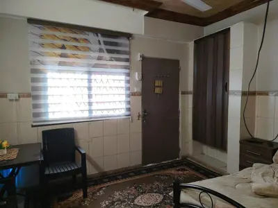 a room with a door and a table and a window at بيت الحجر in Amman