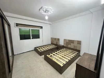 a bedroom with two beds and a window at Beautiful apartment in Irbid