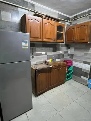 a kitchen with a refrigerator and wooden cabinets at جبال الاردن in Amman