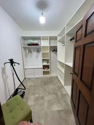 a walk in closet with a green chair and a camera at Luxury spacious house in dabouq with parking in Amman