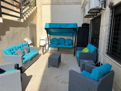 a patio with blue couches and chairs on a building at Luxury spacious house in dabouq with parking in Amman