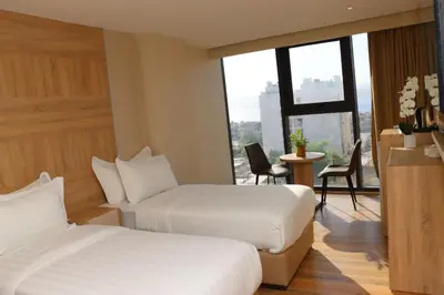 a hotel room with two beds and a window at Ailana Hotel in Aqaba