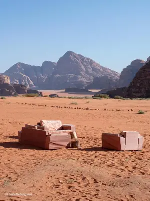 two couches sitting on the sand in the desert at Ruby Orbit Wadi Rum in Wadi Rum