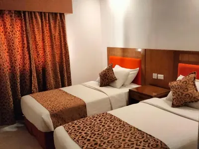 a hotel room with two beds with orange curtains at Petra Rocks Hotel in Wadi Musa