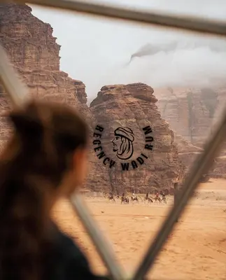 a person looking at a painting of a view of the desert at Regency Bubble Wadi Rum in Wadi Rum