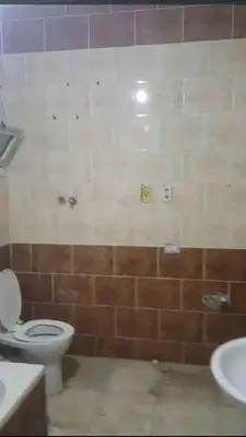 a bathroom with a toilet and a sink at 77 apartment in Abū aş Şalīḩ